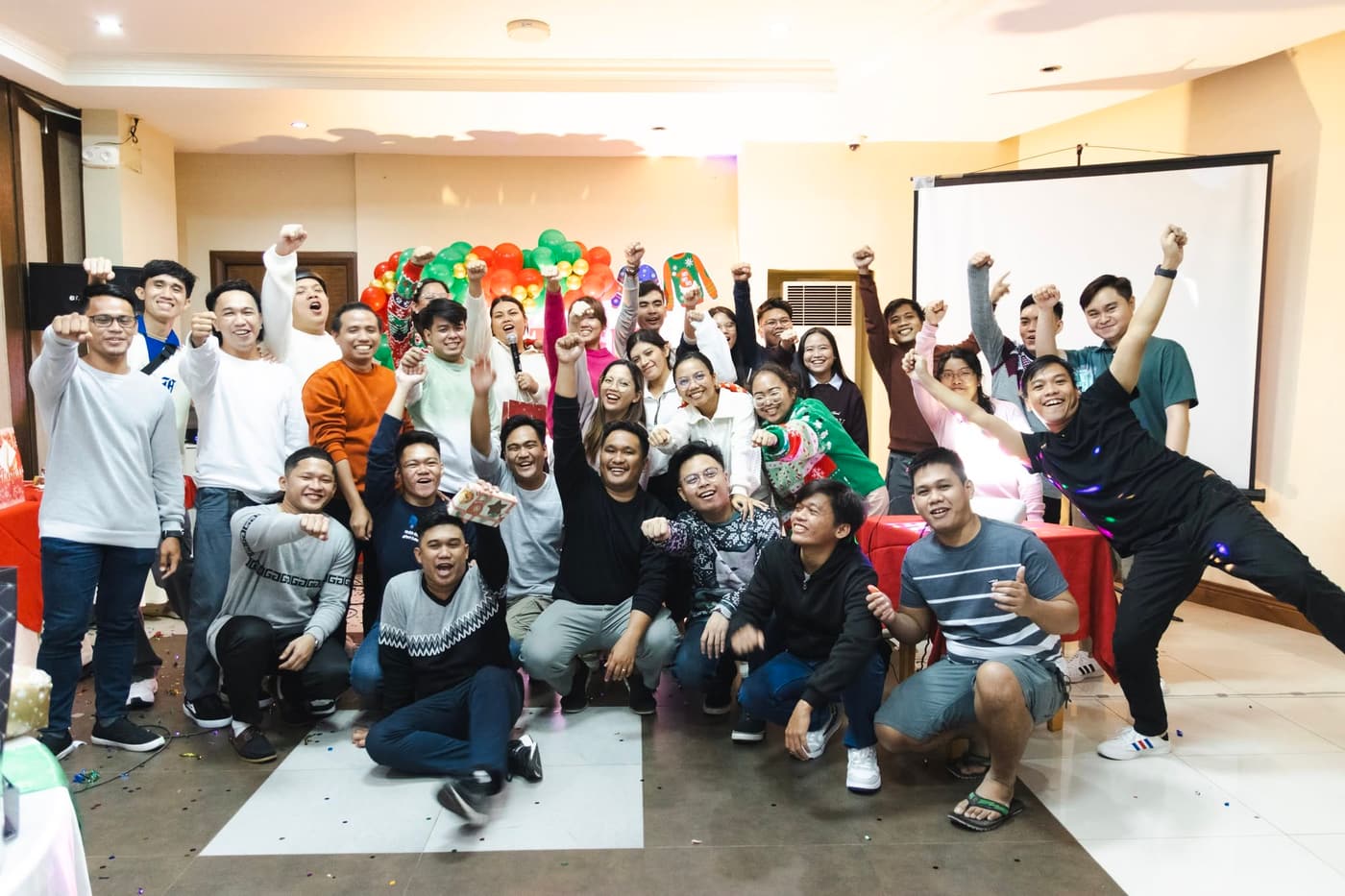 The Sun* Philippines team cheering together, arms raised, at their Christmas party.