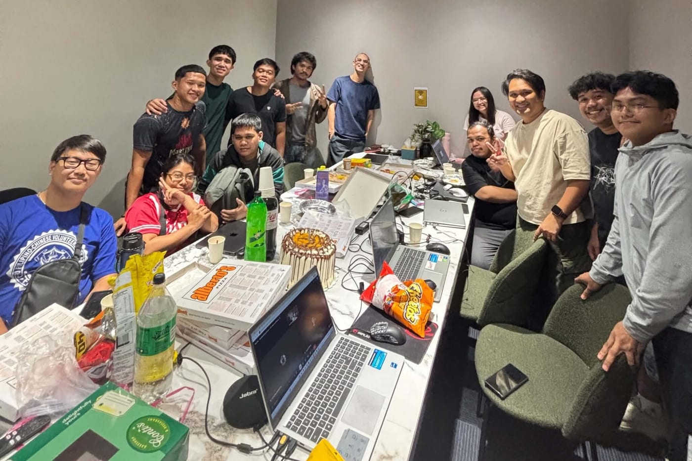 The Sun* Philippines team crowded together around a long table in the co-working room, snacks and laptops out, posing for a group photo.